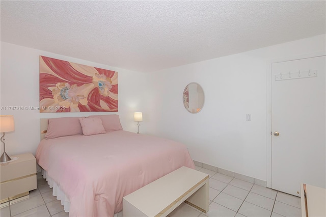 bedroom with baseboards, a textured ceiling, and light tile patterned flooring