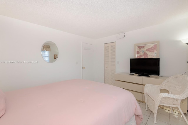 tiled bedroom featuring a closet and a textured ceiling