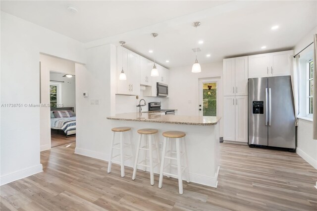 interior space featuring vaulted ceiling, a notable chandelier, and light hardwood / wood-style floors