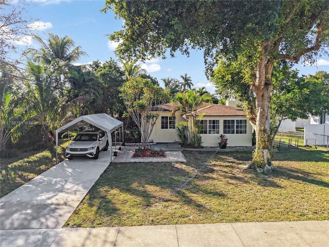 view of front of home with a front lawn and a carport