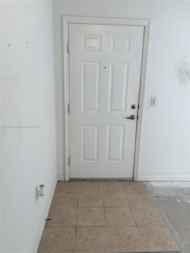 doorway to outside with tile patterned flooring