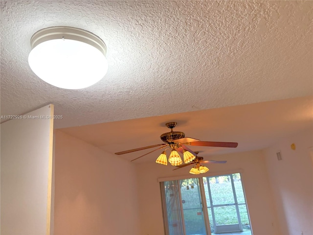 room details featuring a ceiling fan and a textured ceiling