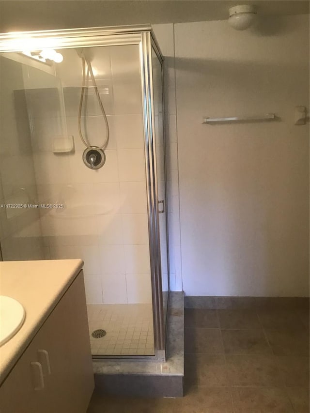 full bathroom with a shower stall, tile patterned floors, and vanity