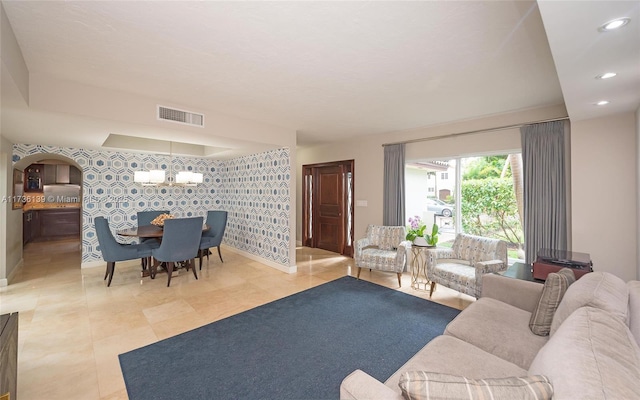 tiled living room featuring a notable chandelier