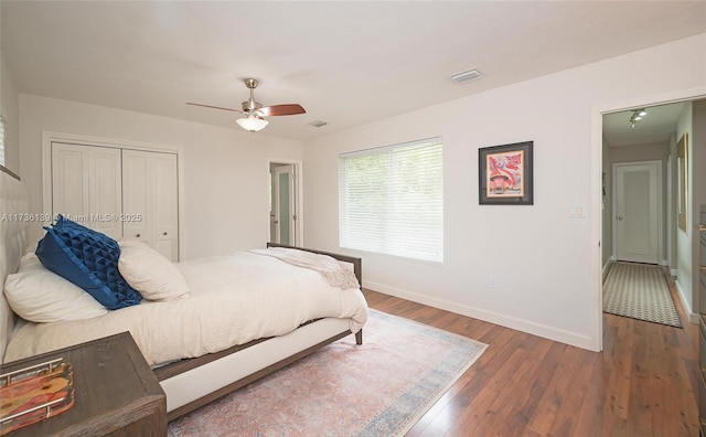 bedroom with dark wood-type flooring, a closet, and ceiling fan