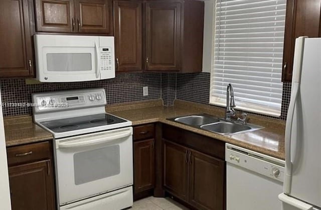 kitchen featuring white appliances, sink, dark brown cabinets, and backsplash