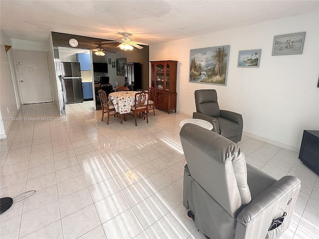 living room with light tile patterned floors, a textured ceiling, and ceiling fan