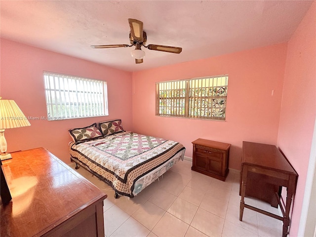 tiled bedroom featuring multiple windows and ceiling fan