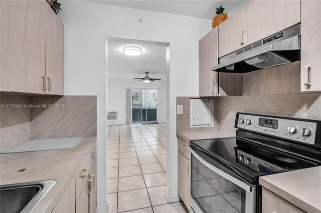 kitchen featuring light tile patterned floors, sink, ceiling fan, stainless steel range with electric stovetop, and backsplash