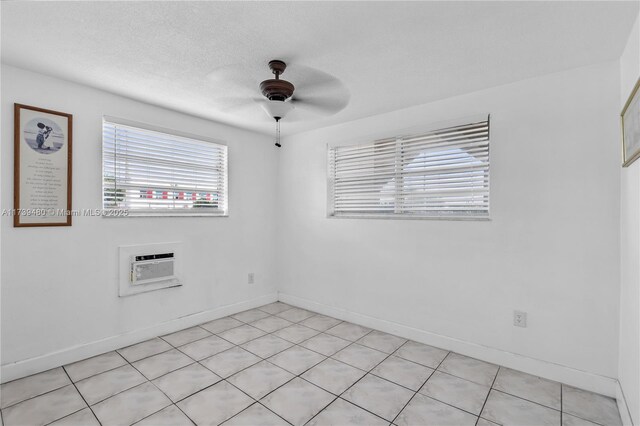 unfurnished room with a wall mounted air conditioner, a textured ceiling, and ceiling fan