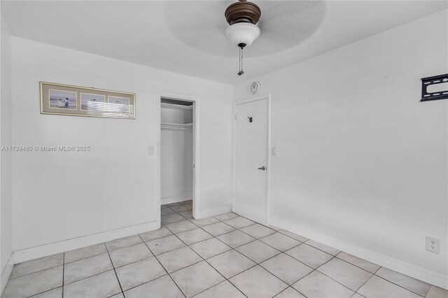 unfurnished bedroom featuring light tile patterned floors, ceiling fan, and a closet