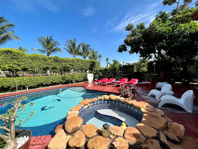 view of pool with a patio area and an in ground hot tub