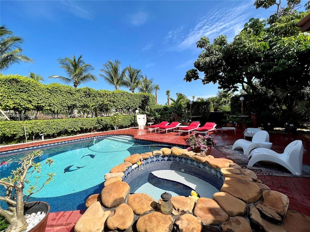 view of pool with a patio and an in ground hot tub