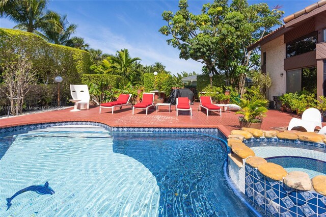 view of pool featuring a patio area and an in ground hot tub