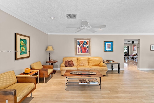 living room with ornamental molding, ceiling fan, a textured ceiling, and light hardwood / wood-style flooring