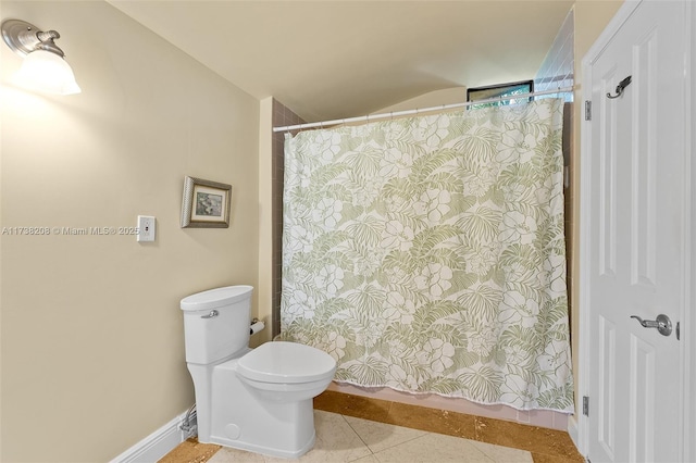 bathroom featuring walk in shower, toilet, and tile patterned flooring