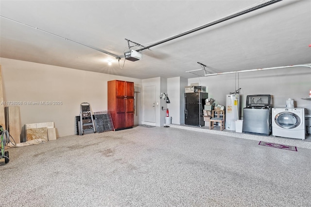 garage with a garage door opener, washing machine and dryer, electric water heater, and black refrigerator