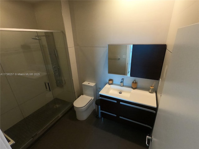 bathroom featuring vanity, toilet, and a shower with door