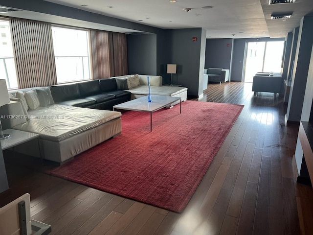 living room featuring plenty of natural light and dark hardwood / wood-style flooring