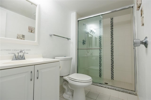 bathroom with tile patterned floors, vanity, toilet, and a shower with door