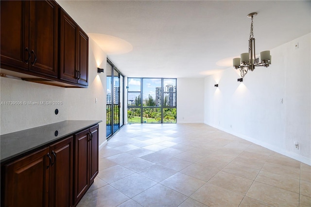 interior space featuring an inviting chandelier, hanging light fixtures, dark brown cabinets, and floor to ceiling windows