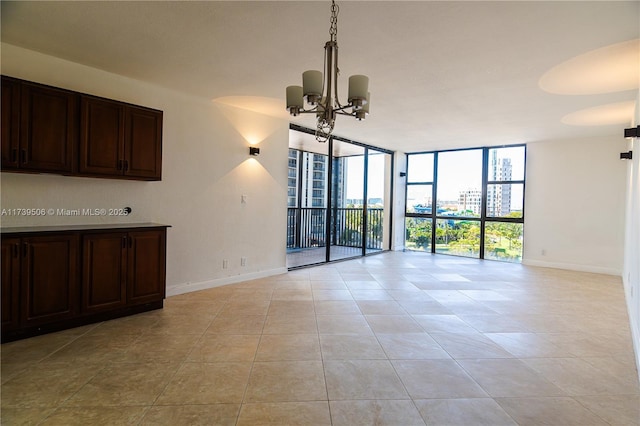 unfurnished living room with expansive windows, a chandelier, and light tile patterned flooring