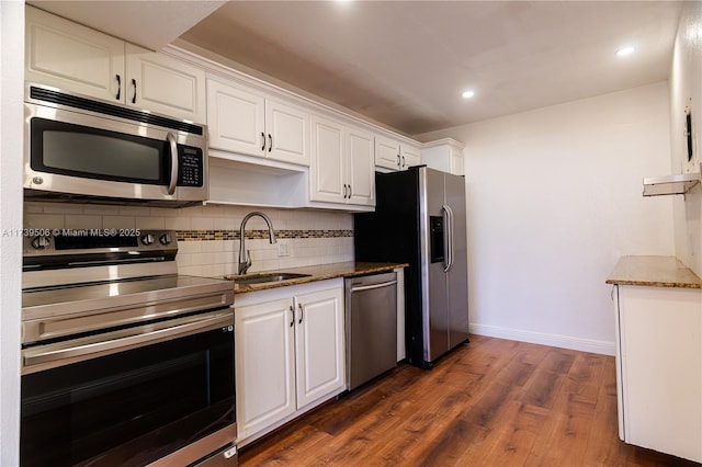 kitchen featuring appliances with stainless steel finishes, sink, decorative backsplash, and white cabinets