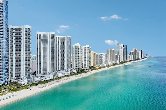 birds eye view of property featuring a water view, a view of the beach, and a city view