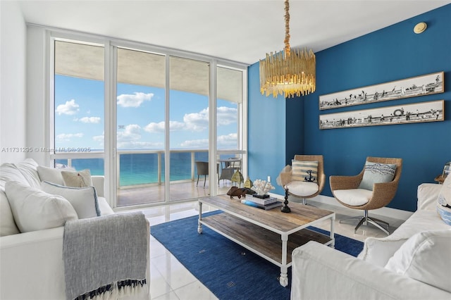 living area featuring baseboards, a chandelier, a water view, tile patterned flooring, and floor to ceiling windows