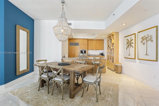 dining room featuring a tray ceiling, a notable chandelier, light tile patterned floors, visible vents, and baseboards