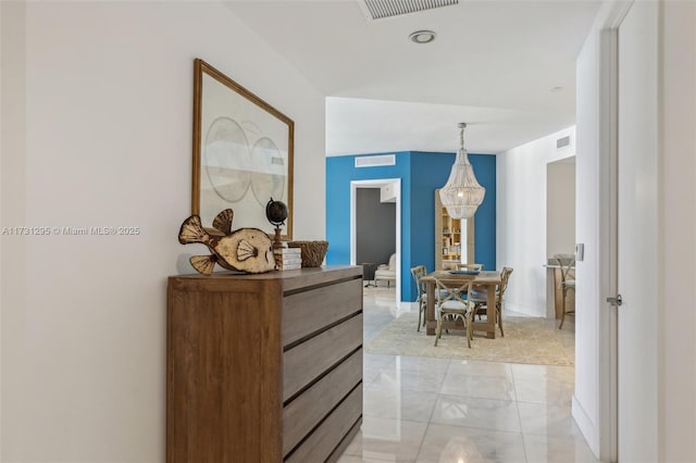 hallway with visible vents and a chandelier