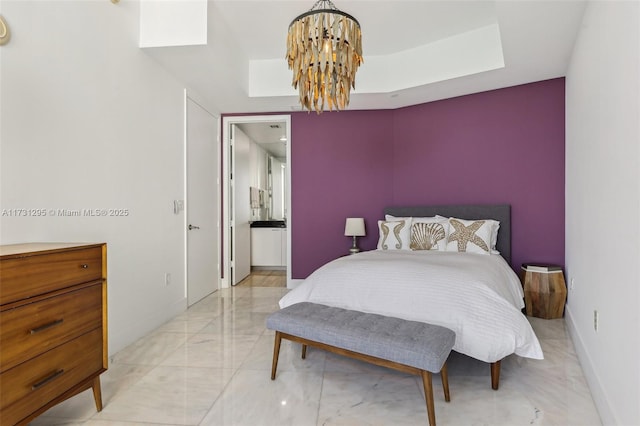 bedroom featuring marble finish floor, a tray ceiling, an inviting chandelier, and baseboards