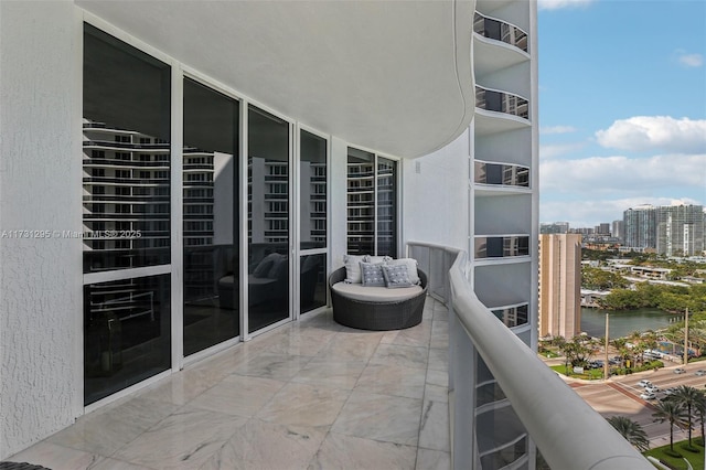 balcony featuring a water view and a city view