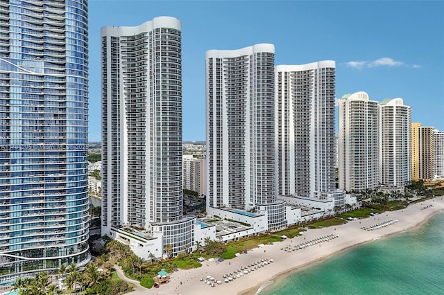 aerial view with a water view, a view of the beach, and a city view