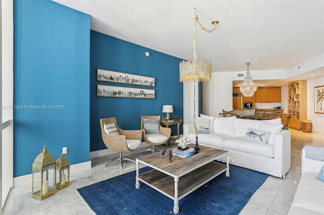 living area with marble finish floor, baseboards, and a chandelier