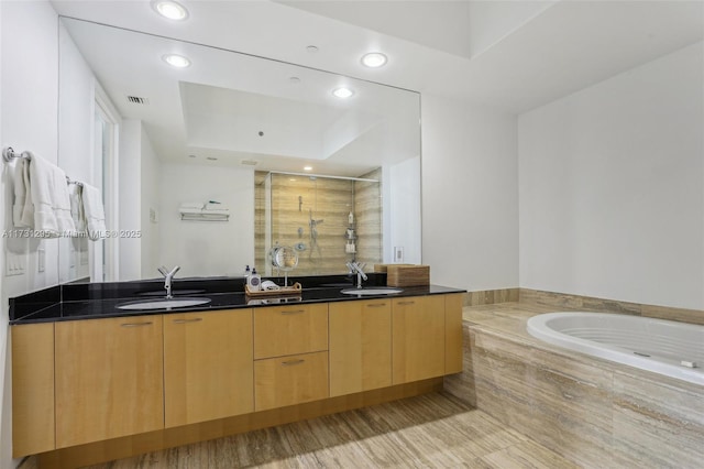 kitchen featuring dark stone counters, a sink, recessed lighting, and modern cabinets