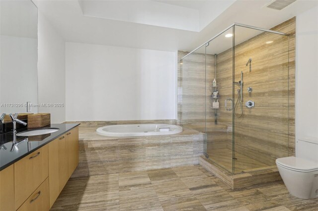 bathroom featuring a garden tub, toilet, vanity, visible vents, and a stall shower