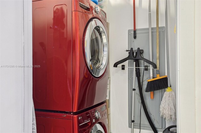 clothes washing area featuring stacked washer / dryer and laundry area