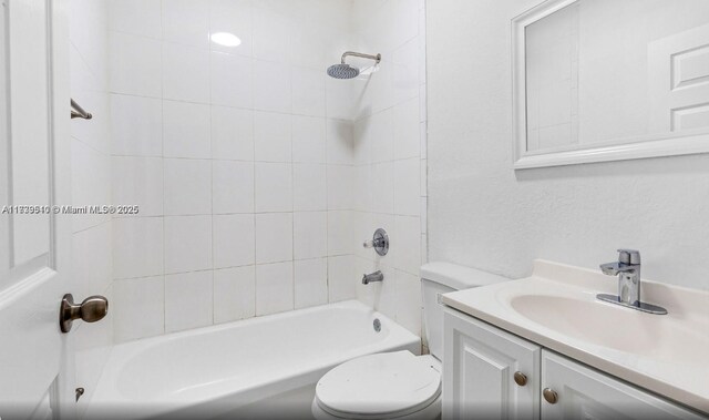 full bathroom featuring tiled shower / bath combo, vanity, and toilet