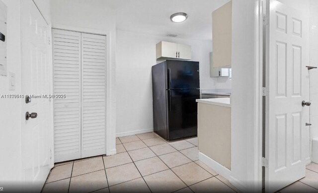 kitchen featuring black refrigerator and light tile patterned floors