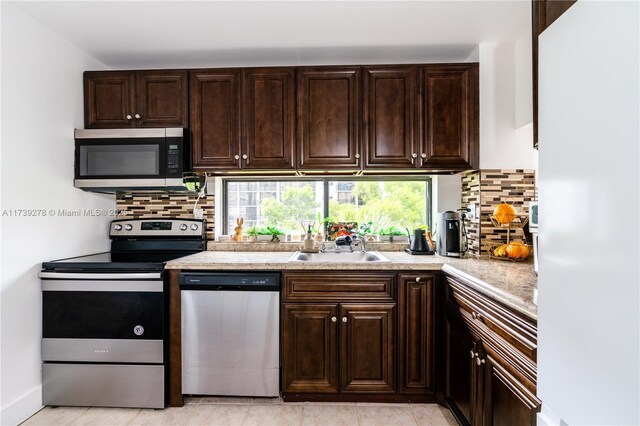 kitchen with sink, backsplash, dark brown cabinets, and appliances with stainless steel finishes