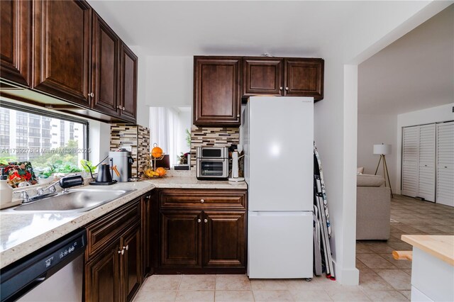 kitchen with sink, dishwasher, dark brown cabinets, white refrigerator, and decorative backsplash