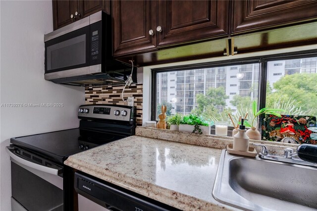 kitchen with stainless steel appliances, dark brown cabinets, sink, and decorative backsplash