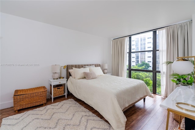 bedroom featuring hardwood / wood-style flooring and expansive windows