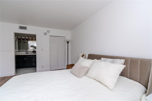 bedroom with sink, ensuite bath, and a closet