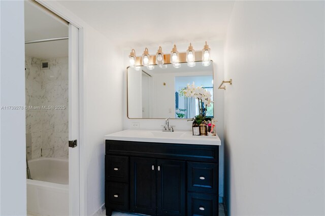 bathroom featuring vanity and tiled shower / bath