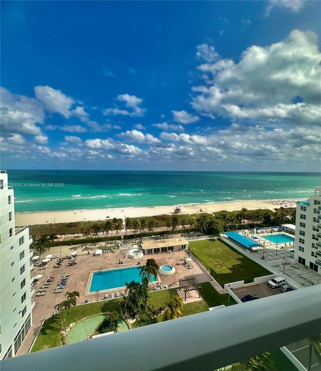 drone / aerial view featuring a beach view and a water view