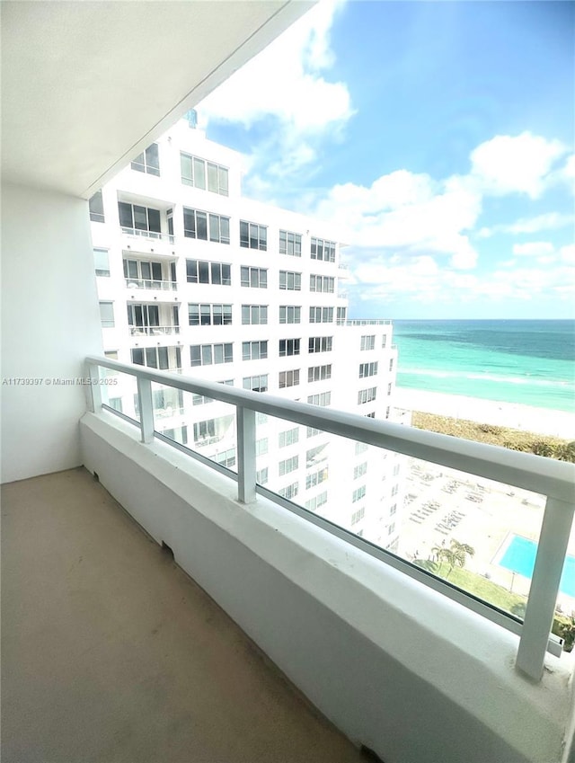 balcony featuring a water view and a view of the beach