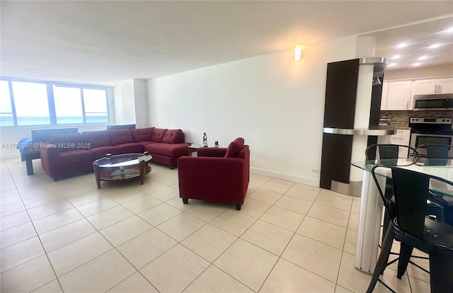 living area featuring light tile patterned floors and baseboards