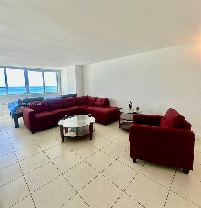 living room featuring a water view and light tile patterned flooring